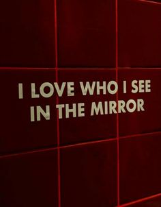 i love who i see in the mirror sign on a red wall with white lettering