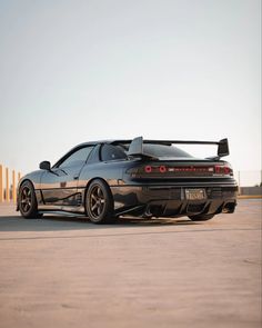 a black sports car parked on top of a parking lot