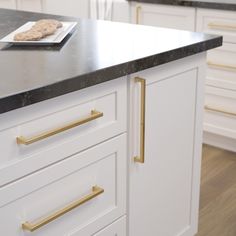 This Casual Square pull from Brainerd is a casual cabinet hardware design that can be used on a wide range of furniture pieces. Soft edges lend a laid-back charm to this pull. From kitchen cupboards to vanity drawer handles, the 5-pack of square pulls is a lovely addition to make your home feel polished. Brainerd Casual Square 10-1/16-in (256Mm) Center to Center Brushed Brass Rectangular Bar Appliance Pull (5-Pack) in Gold | P48475W-117-B Brushed Gold Hardware Kitchen, White Kitchen Gray Countertops, Kitchen Grey Countertops, Gold Hardware Kitchen, Appliance Pulls Hardware, Gold Kitchen Hardware, Gold Cabinet Hardware, Vanity Drawer, Gold Cabinet Pulls