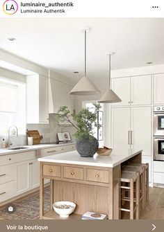 a large kitchen with white cabinets and an island in the middle is featured on this page