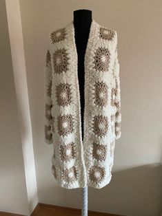 a white and brown cardigan on a mannequin