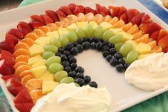 a rainbow shaped cake with fruit on it