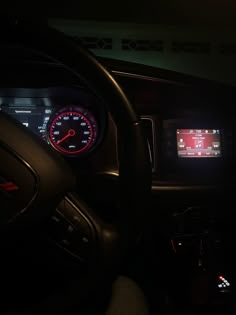 the interior of a car with dashboard lights and gauges on display in the dark