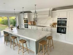 a large kitchen with an island counter and stools