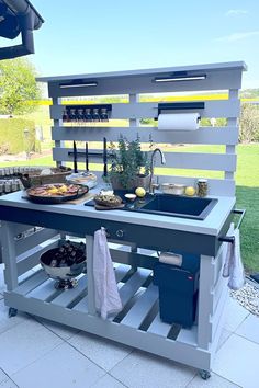 an outdoor kitchen made out of pallets with food on the counter and sink below