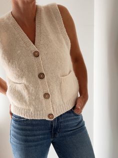 a woman is wearing a sweater and jeans