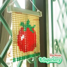 there is a beaded picture hanging on the side of a building that says strawberry