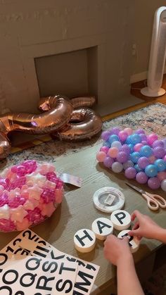 a table topped with lots of different types of cookies and balloons on top of it