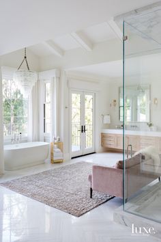 a large bathroom with a tub, sink and glass doors leading to the outside patio