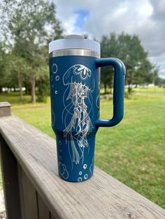 a blue coffee cup sitting on top of a wooden bench