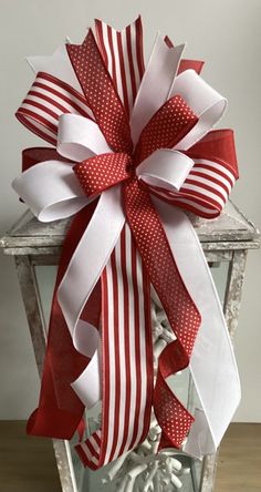 a large red and white bow on top of a lantern