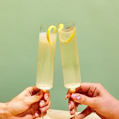 two people toasting with lemons and holding wine glasses