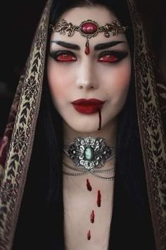 a woman with blood on her face and red eyes is dressed up as a vampire