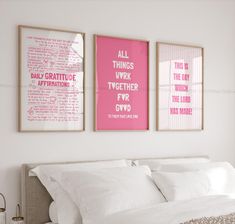 two pink posters on the wall above a bed