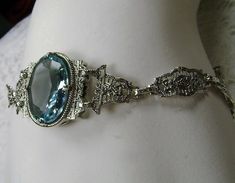 "<> (Made To Order) This is a brand new Victorian/Art Deco Reproduction filigree sterling silver gemstone bracelet. The gorgeous 6ct oval cut Simulated/man-made aquamarine gemstone is 14mm x 10mm x 6mm in dimension. Notice the beautiful craftsmanship of the filigree settings and links. This is a well made beautiful bracelet and it is ready to wear. The bracelet is adjustable and will fit from 7\" to 8.5.\"The color and clarity of each gemstone are excellent. A gift-box is included for safe Formal Oval Bracelet With Engraving, Formal Oval Bracelets With Engraving, Formal Oval Bracelet With Engraved Details, Formal Engraved Oval Bracelet, Ornate Oval Engraved Bracelets, Vintage Blue Oval Bracelets, Vintage Blue Oval Bracelet, Formal Oval Estate Jewelry, Antique Oval Link Bracelet For Formal Occasions