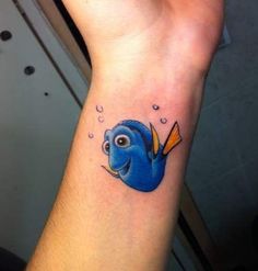 a small blue fish tattoo on the wrist