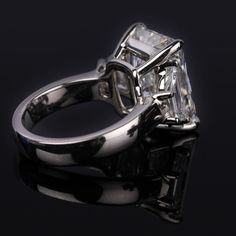 an engagement ring with a princess cut diamond in the center on a black background photo