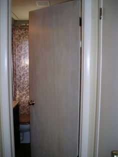 an open door leading to a bathroom with a sink and toilet in the corner behind it