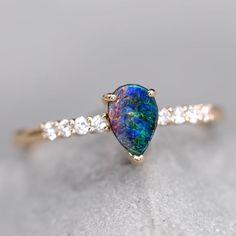 Fantastic Australian Opal Jewelry Stylish Two-Color Australian Boulder Opal & Diamond Engagement Ring 18K Yellow Gold.  Free Domestic USPS First Class Shipping! Free Gift Bag/Box with every order! Every Opal piece is Unique. We only use high quality Natural Australian Opals ( NO synthetics or imitations). Quality is our commitment. Please do not hesitate to contact me if you have any questions or concerns:) *All pictures were taking under the natural light. ABOUT THIS PRODUCT 18K Yellow Gold Australian Boulder Opal, 0.55 ct 8 Diamond: 0.113 ct Opal Size: 7 x 4.5 mm Opal Brightness: B4 Very Bright Opal Color: Reflects Red, Green, and Yellow Colors. Ring Size: 7 Occasion: Engagement/Anniversary Re-sizing: The ring size is 7.  We size down the ring for free, and $20 extra for sizing up.  Ther Multicolor Pear-shaped Jewelry For Anniversary, Opal Diamond Engagement Ring, Rarest Gemstones, Gold Opal Engagement Ring, Boulder Opal Jewelry, Opal Promise Ring, Australian Opal Jewelry, Promise Bracelet, Boulder Opal Ring