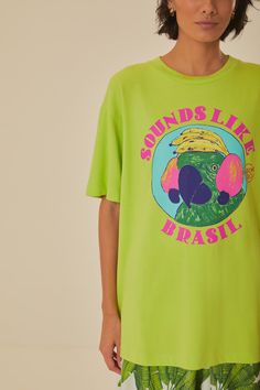 Immerse yourself in tropical vibes with the Green Sounds Like Brasil Organic Cotton T-Shirt by FARM Rio. This vibrant piece features a lively round neckline and a relaxed fit that drapes effortlessly for a comfy yet stylish feel. The bright green hue serves as a canvas for a playful parrot graphic, encapsulated with bold, lively text, offering a burst of Brazilian spirit. Crafted from soft organic cotton, this tee invites a touch of nature's comfort to your everyday wardrobe. Composition 100% COTTONCare Instructions MACHINE WASH, GENTLE CYCLE, DO NOT BLEACH, DO NOT TUMBLE DRY, LINE DRYING, IRON AT MEDIUM HEAT, DRY CLEAN WITH ANY SOLVENT EXCEPT TRICHLOROETHYLENESize and Fit Inches XXS XS S M L XL Bust 40 2/4 42 2/4 44 2/4 46 2/4 49 2/4 52 2/4 Waist 40 3/4 42 3/4 45 46 3/4 49 3/4 52 3/4 Leng Trendy Green Printed Top, Green Printed Crew Neck Top, Casual Green Printed Tops, Green Trendy Top With Graphic Print, Casual Green Top With Front Print, Cotton T-shirt With Tropical Print, Cotton Tropical Print T-shirt, Tropical Green Relaxed Fit Tops, Trendy Green T-shirt For Summer