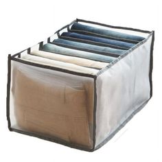 an open storage bag filled with clothes on top of a white surface and black trim around the bottom