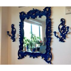 a blue mirror hanging on the wall next to a potted plant