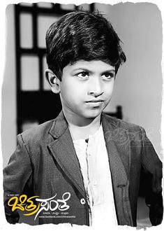 black and white photograph of a young boy in a suit with his eyes wide open