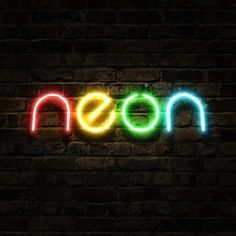 a neon sign that reads moon on a brick wall in front of a dark background