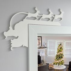 a christmas tree in front of a mirror with santa's sleigh on it