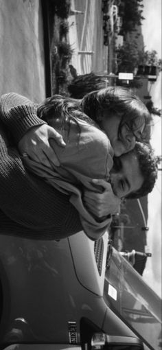 black and white photo of two people hugging each other