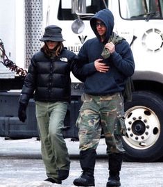 two people walking in front of a semi truck