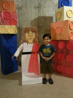 a young boy standing next to a cardboard character