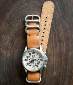 After years of creating leather watch straps for ourselves for use on a variety of watches, we are excited to release our version of the simple NATO leather strap. The NATO strap has an iconic history for a range of vintage military issued watches. We've tested this strap on a variety of watches, from Tudor to Rolex and Timex to Luminox. It's a beautiful addition to new and vintage watches. Three widths available: 18mm, 20mm, and 22mm All straps are precisely cut from 4 ounce bridle leather and Nato Watch Strap, Brown Apple, Nato Strap Watches, Black Apple, Nato Strap, Handmade Leather Wallet, Vintage Military, Watch Straps, Leather Watch Strap