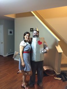 a man and woman dressed up in costumes standing next to each other on a hard wood floor