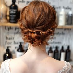 the back of a woman's head with red hair styled into a low bun