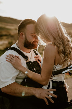 a man and woman embracing each other in the sun