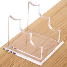 a clear acrylic holder on a wooden table with two metal poles sticking out of it