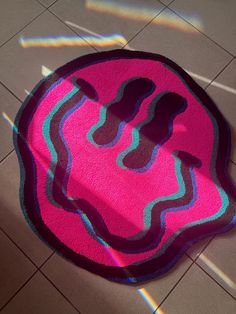 a pink and blue rug on the floor with light coming in from it's shadow