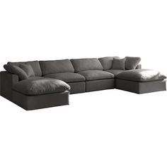 a large gray sectional couch with pillows on it's back and footrests