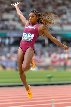 a woman is jumping in the air on a track