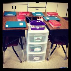 a classroom desk with several bins on it