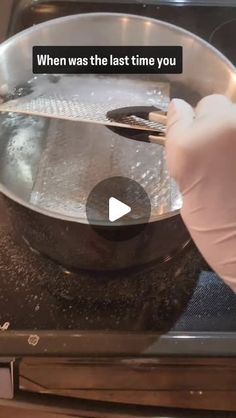 a person in white gloves is cooking something on the stove