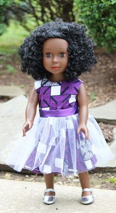 the doll is wearing a purple dress and silver shoes