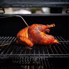 a whole chicken is on the grill with it's legs still in the oven