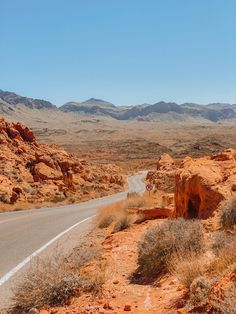 an open road in the desert with mountains in the background