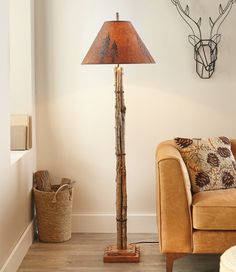 a living room with a couch, lamp and deer head on the wall