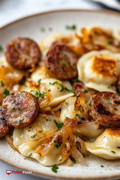 a white plate topped with dumplings and sausages on top of pasta covered in sauce