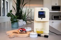 an appliance sitting on top of a kitchen counter next to bowls and cups