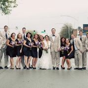 a group of people standing next to each other in front of a street with trees