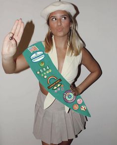 a woman in a skirt and hat holding up a green sash with the number 50 on it